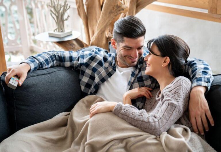 Couple watching tv while on sofa